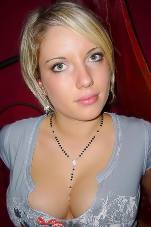 Blonde-haired busty teen gets naked and shows off